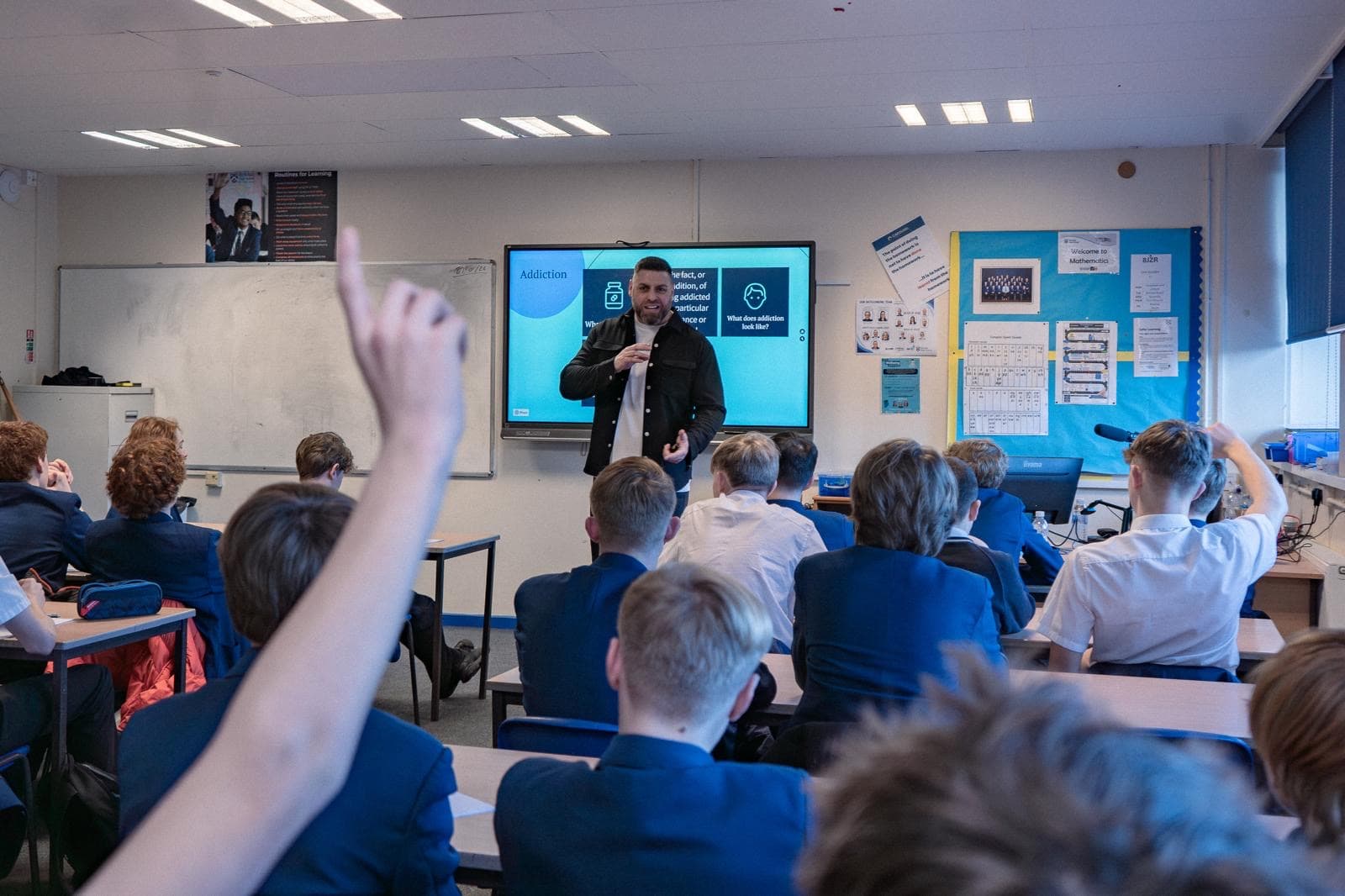 Mark delivering a session — student raising hand to engage