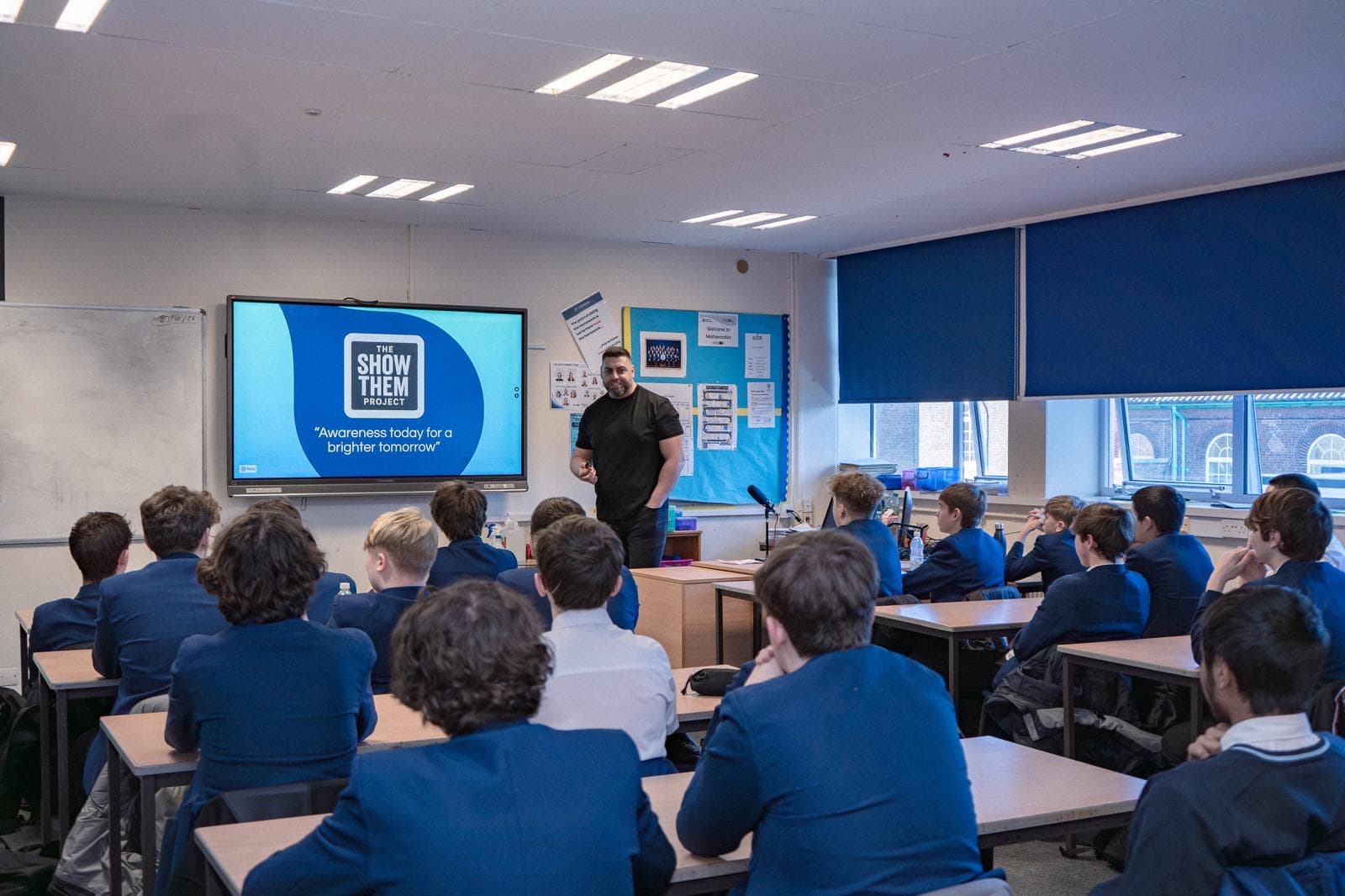 Mark speaking to a full classroom of students